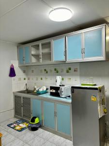 eine Küche mit blauen Schränken und einem Kühlschrank in der Unterkunft Popular condo T8 Near Impact. in Thung Si Kan
