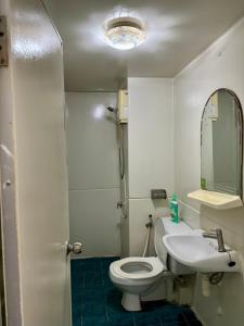 ein Badezimmer mit einem WC, einem Waschbecken und einem Spiegel in der Unterkunft Popular condo T8 Near Impact. in Thung Si Kan