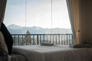 een bed in een kamer met een groot raam bij ESSPEEDY Hill Forest Cottages and Yoga Centre in Ella