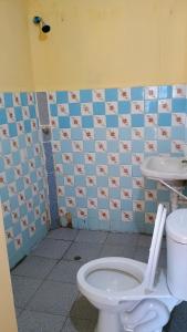 a bathroom with a toilet and a tiled wall at Casas Cueva in Tumbes