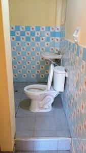 a bathroom with a toilet and a blue tiled wall at Casas Cueva in Tumbes