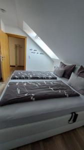 Cama grande en habitación con ático en Living Apartment, en Hittisau