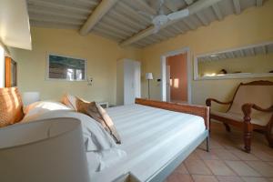 1 dormitorio con 1 cama grande y 1 silla en Le Versegge Resort, en Braccagni