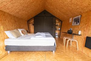 1 dormitorio con 1 cama y TV en una habitación en Tenthuisje met hottub in Callantsoog, en Callantsoog