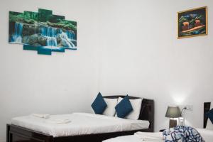 een slaapkamer met 2 bedden en een schilderij aan de muur bij ESSPEEDY Hill Forest Cottages and Yoga Centre in Ella