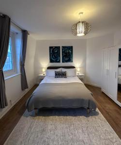 a bedroom with a large bed with two tables and a chandelier at City Nights - London in London