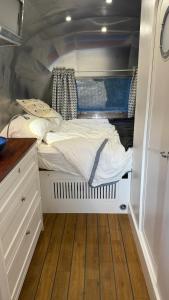 a small bedroom with a bed in an rv at Airstream Experience in Knutsford