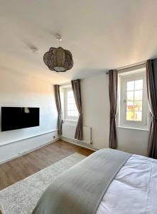 - une chambre avec un lit et une télévision à écran plat dans l'établissement City Nights - London, à Londres