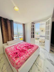 um quarto com uma cama grande e lençóis cor-de-rosa em El Mesala Hotel em Luxor