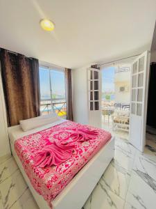 a bedroom with a large bed with pink sheets at El Mesala Hotel in Luxor