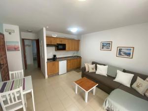 ein Wohnzimmer mit Sofa und eine Küche in der Unterkunft Cascada de colores in Los Cancajos