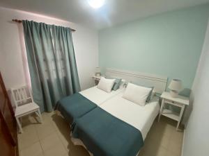 ein Schlafzimmer mit einem großen Bett mit blau-weißer Bettwäsche in der Unterkunft Cascada de colores in Los Cancajos + 19 Fotos