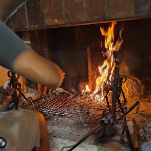 uma pessoa está cozinhando sobre uma fogueira em um forno em Casa Maja - Sant'Eufemia a Maiella em SantʼEufemia a Maiella