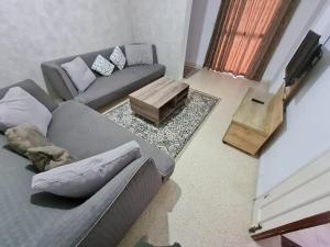 a living room with a couch and a coffee table at Bienvenue dans votre appartement in Gabès