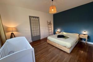 1 dormitorio con cama blanca y pared azul en Les Sablons - 15pers near Disneyland & Paris, en La Houssaye-en-Brie