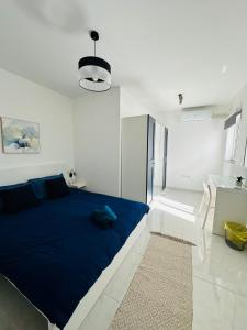 Una gran cama azul en una habitación blanca en Sliema 2 Bedroom Penthouse, en Sliema