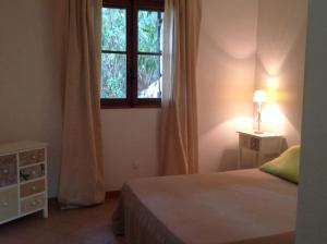 een slaapkamer met een bed en een raam bij Villa Marie-Diane F4 in Propriano