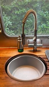um lavatório com uma torneira ao lado de uma janela em Airstream Experience em Knutsford