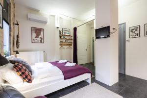 - une chambre avec un lit et une télévision murale dans l'établissement Paulay Deluxe studio, à Budapest