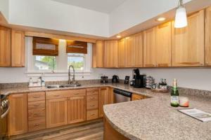 a kitchen with wooden cabinets and a granite counter top at New Near Beach Casino Dunes Zoo& Restaurants in Michigan City