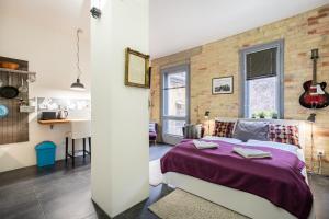 - une chambre avec un mur en briques et un lit dans l'établissement Paulay Deluxe studio, à Budapest