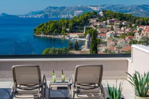 "Villa AnMari" The Cavtat View Residence في كافتات: طاولة وكراسي على شرفة مطلة على الماء