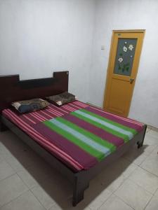 a bed in a room with a wooden door at 67 holiday home in Badulla