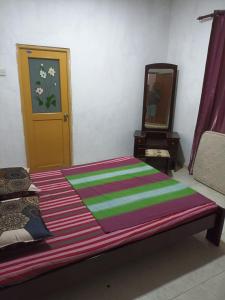 een slaapkamer met een bed met een kleurrijke deken erop bij 67 holiday home in Badulla