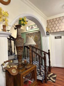 シュリーナガルにあるHeritage Rose Innのテーブルに花瓶を置いた階段のある部屋