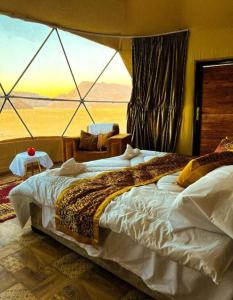 a bedroom with a bed with a view of the desert at Night Magic Camp in Wadi Rum