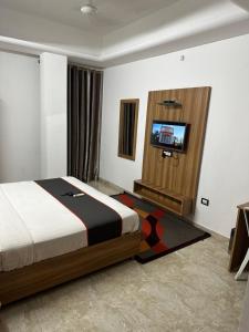 a bedroom with a bed and a flat screen tv at Gulnaar Inn in Chennai