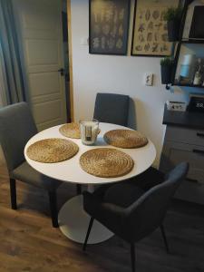 a table with three plates on top of it with chairs at Home Apartman in Nagyesztergár