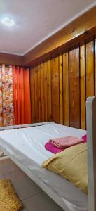 a bed in a room with wooden walls at Sassy's Place in Baguio