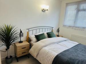 um quarto com uma cama e um vaso de plantas em Entire 5 bedroom detached house free Parking 5 mins driving to Bicester Village em Bicester