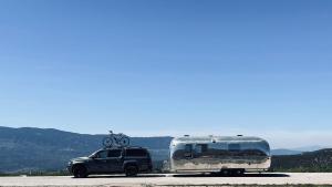 un camión estacionado al lado de un remolque con una bicicleta en el techo en Airstream Experience, en Knutsford