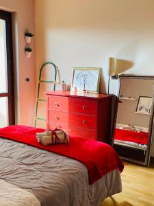 een slaapkamer met een rode dressoir en een spiegel bij A Casa di Amici - intero appartamento - Free parking - wi-fi in Lecce