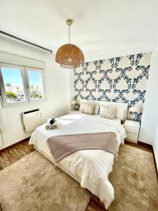 um quarto com uma cama grande e uma parede azul e branca em Huelin Park Apartment em Málaga