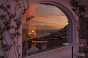 a view of a sunset from a window of a balcony at Grand Hotel Tritone in Praiano