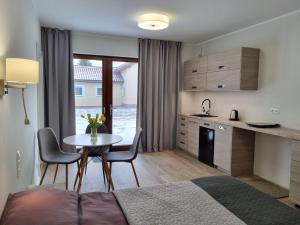 Habitación con cama, mesa y cocina. en Piaskowa 13 - Apartamenty dla Podróżujących bez Dzieci en Nickelswalde