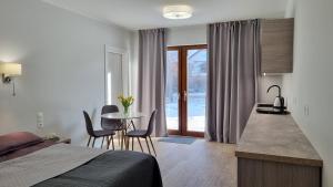 1 dormitorio con 1 cama y 1 mesa con sillas en Piaskowa 13 - Apartamenty dla Podróżujących bez Dzieci en Nickelswalde