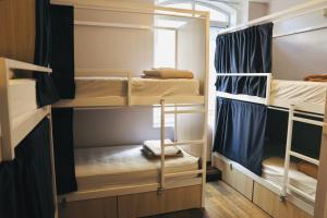 a room with bunk beds with blue curtains at Gspot Hostels & Love Triangles Pizzeria in Lisbon