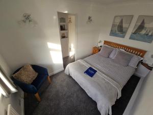 a bedroom with a bed and a blue chair at Beachcomber B&B in Tenby