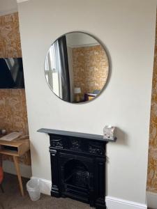 a mirror over a fireplace in a room at Most Easterly (North) in Pakefield