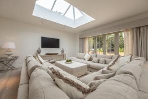 uma ampla sala de estar branca com um grande sofá em The Beach House B em Brancaster