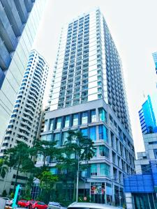 a tall building with a tree in front of it at Cool And Cozy Home By Seri Bukit Ceylon Residency in Kuala Lumpur
