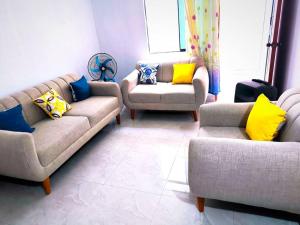 sala de estar con 2 sofás y almohadas amarillas y azules en "Pacae" House, en Ica