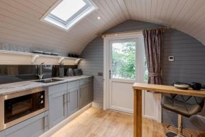 a kitchen with a vaulted ceiling with a skylight at Long Ashes - Pip in Tattenhall
