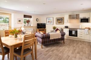 a kitchen and living room with a table and a couch at Dryburgh Steading Two in Saint Boswells
