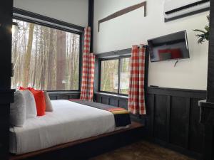 a bedroom with a bed and a tv on a wall at Trekker, Treehouses cabins and lodge rooms in Lake George