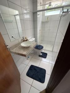 La salle de bains blanche est pourvue d'un lavabo et de toilettes. dans l'établissement Condomínio Colina, à Palmas